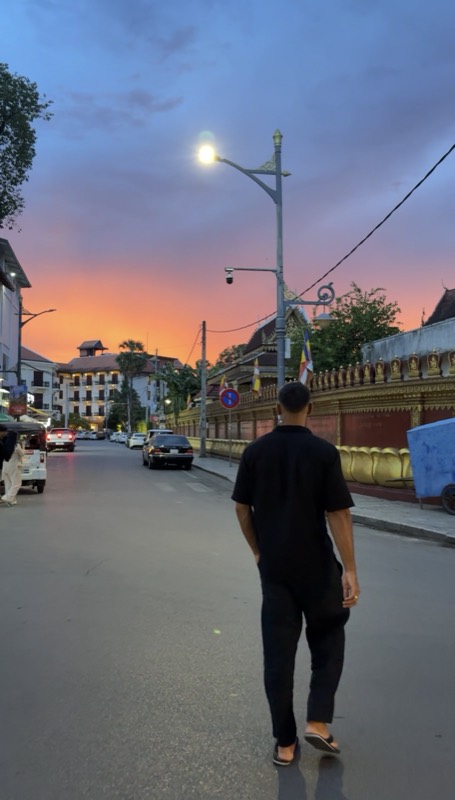 A quiet street at dusk with a purple and orange sky